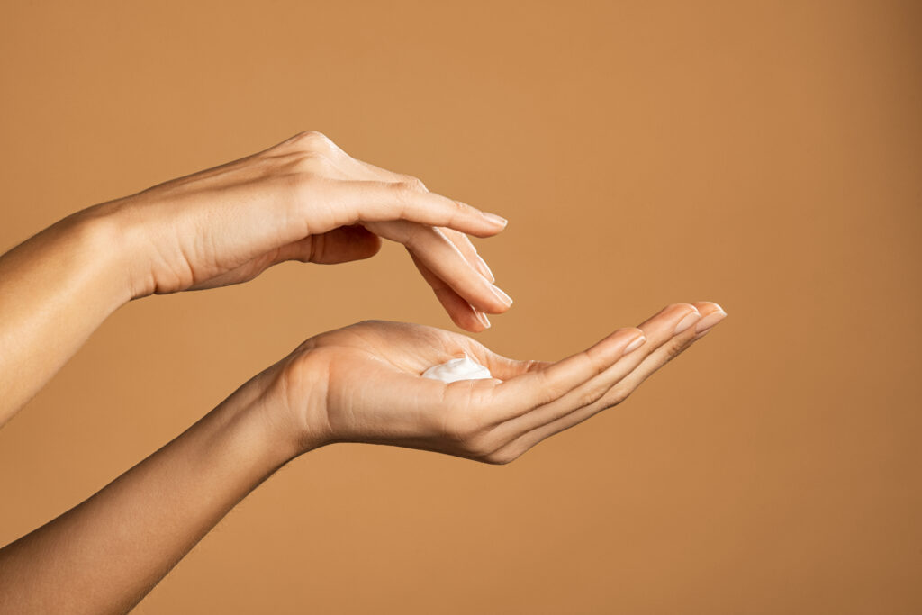 woman hand applying lotion cream