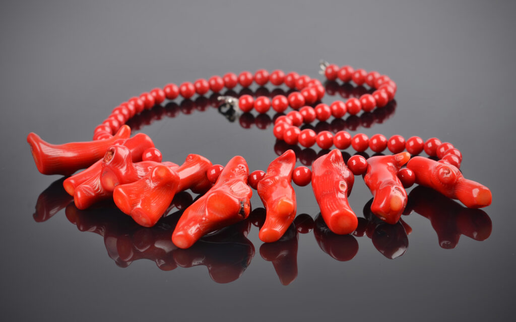 detail of a beautiful red coral necklace on black background