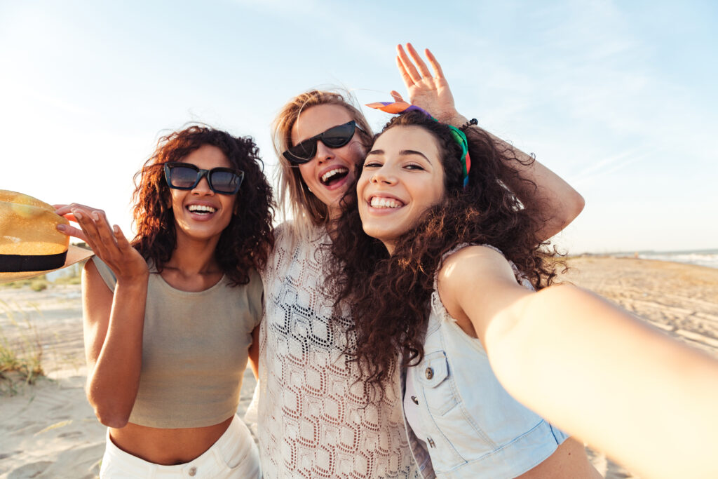 three happy girls friends in summer clothes