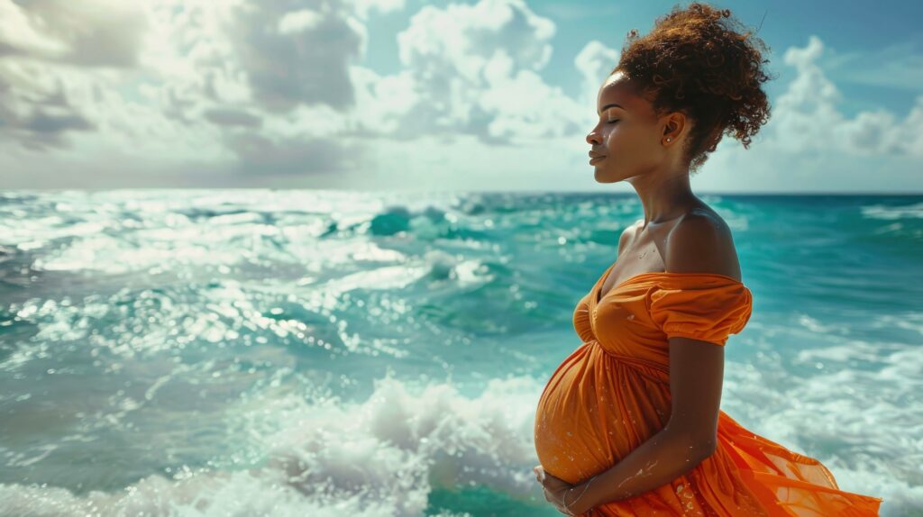 pregnant woman in orange dress standing on the beach and looking at sea