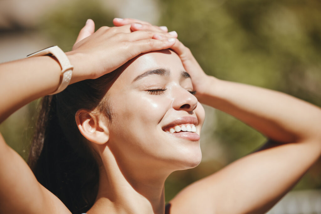 face, relax and happy woman in sunshine, outdoor fresh air and peaceful break for mental health, wellness and body. summer, happiness and smile latino girl relax in nature, park rest and calm freedom