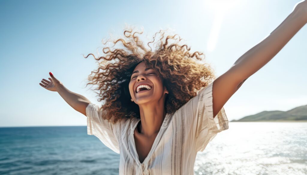 happy woman with arms outstretched enjoying freedom at the beach , joyful female having fun walking outside , healthy lifestyle, happiness and mental health