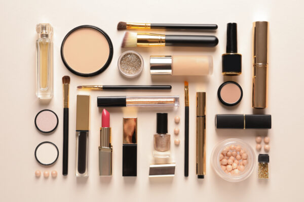 different luxury makeup products on color background, flat lay