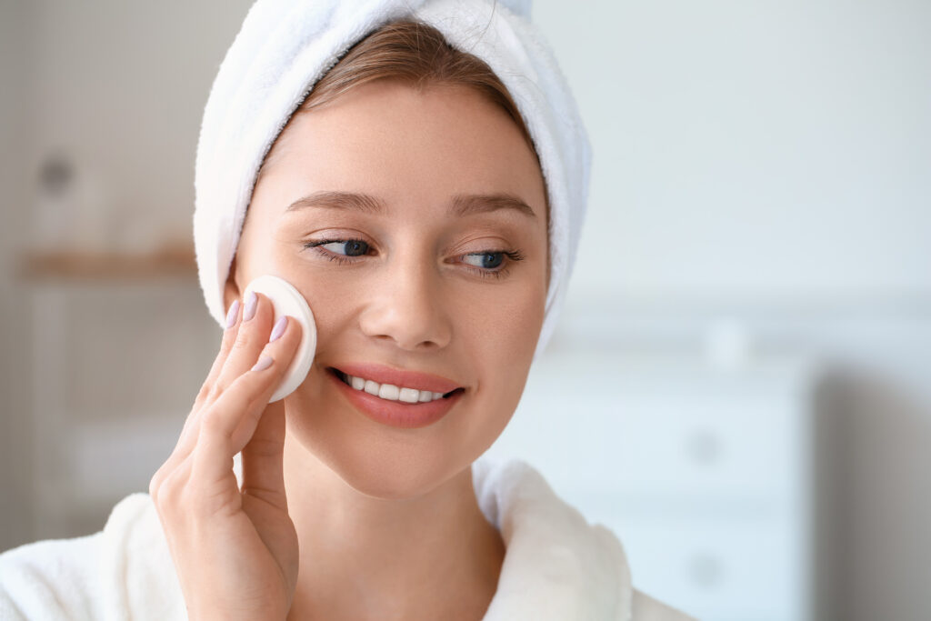 beautiful young woman removing makeup at home